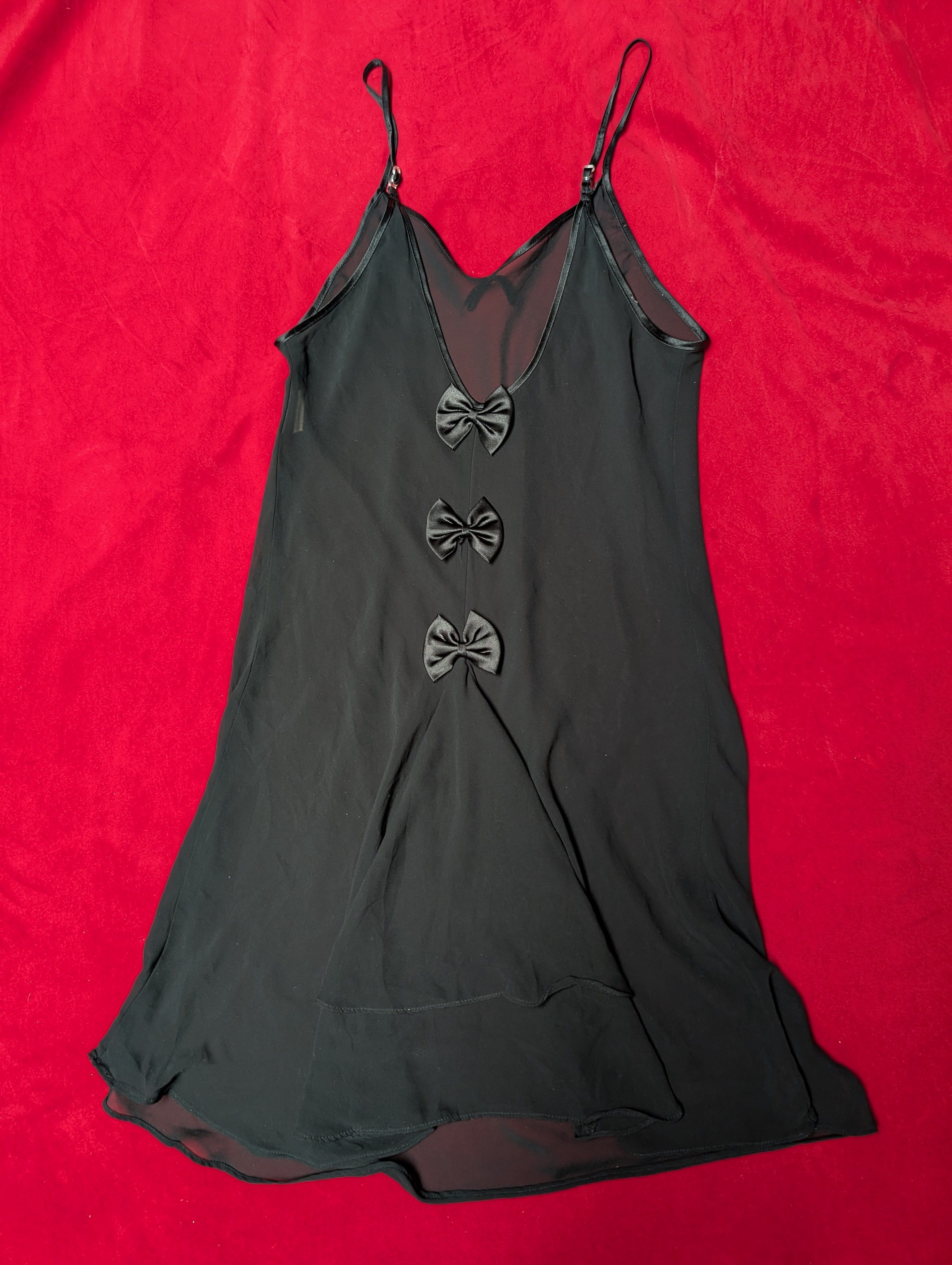 Black dress with floral embellishments on a red background