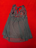 A sheer navy mesh babydoll chemise with a lace halter neckline, laid flat on a vibrant red background.