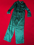 A two-piece satin pajama set in a deep teal green color, laid flat on a bright red background. The set includes a long-sleeve button-up top with a collar and matching pants.