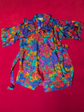 A multicolor floral print kimono-style robe with a tie waist belt and matching babydoll chemise, laid flat on a bright red background.